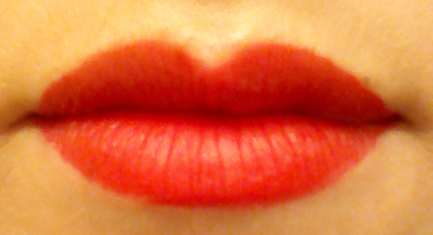 Fluorescent light lip swatch of Revlon Colorstay Ultimate Liquid Lipstick in Top Tomato